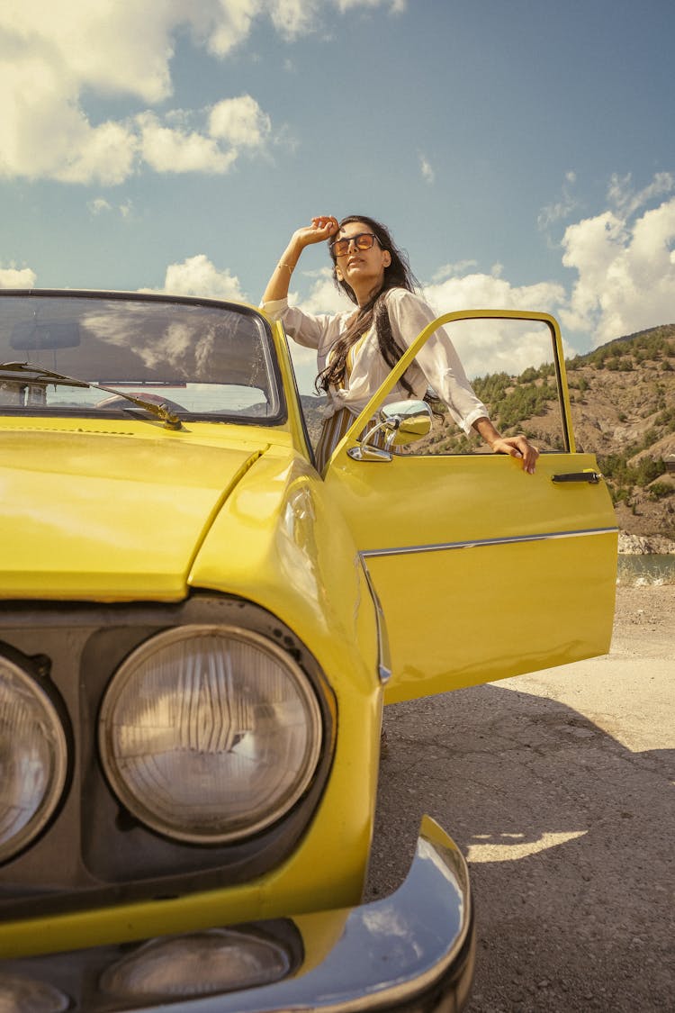 Woman Standing At Yellow Vintage Car