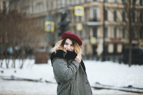 女人在下雪天穿外套和紅色的帽子