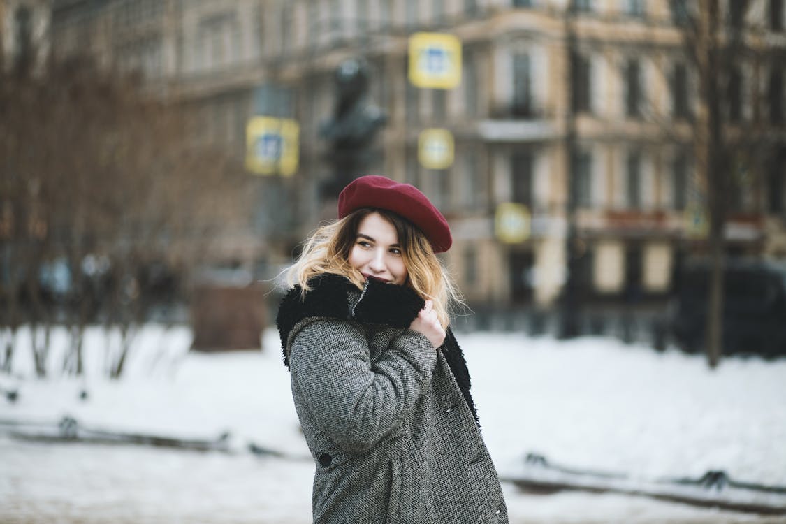 Woman Wearing Coat and Red Hat during Snowy Day