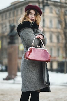 一位穿着冬季外套、戴着贝雷帽的时尚女士，在户外拿着手提包