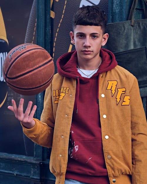 A Man in Brown Jacket Holding a Ball