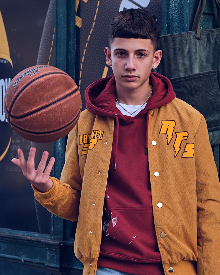 A Man In Brown Jacket Holding A Ball