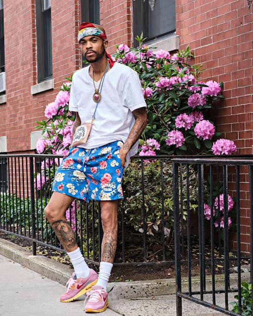 Man Leaning on Metal Fence