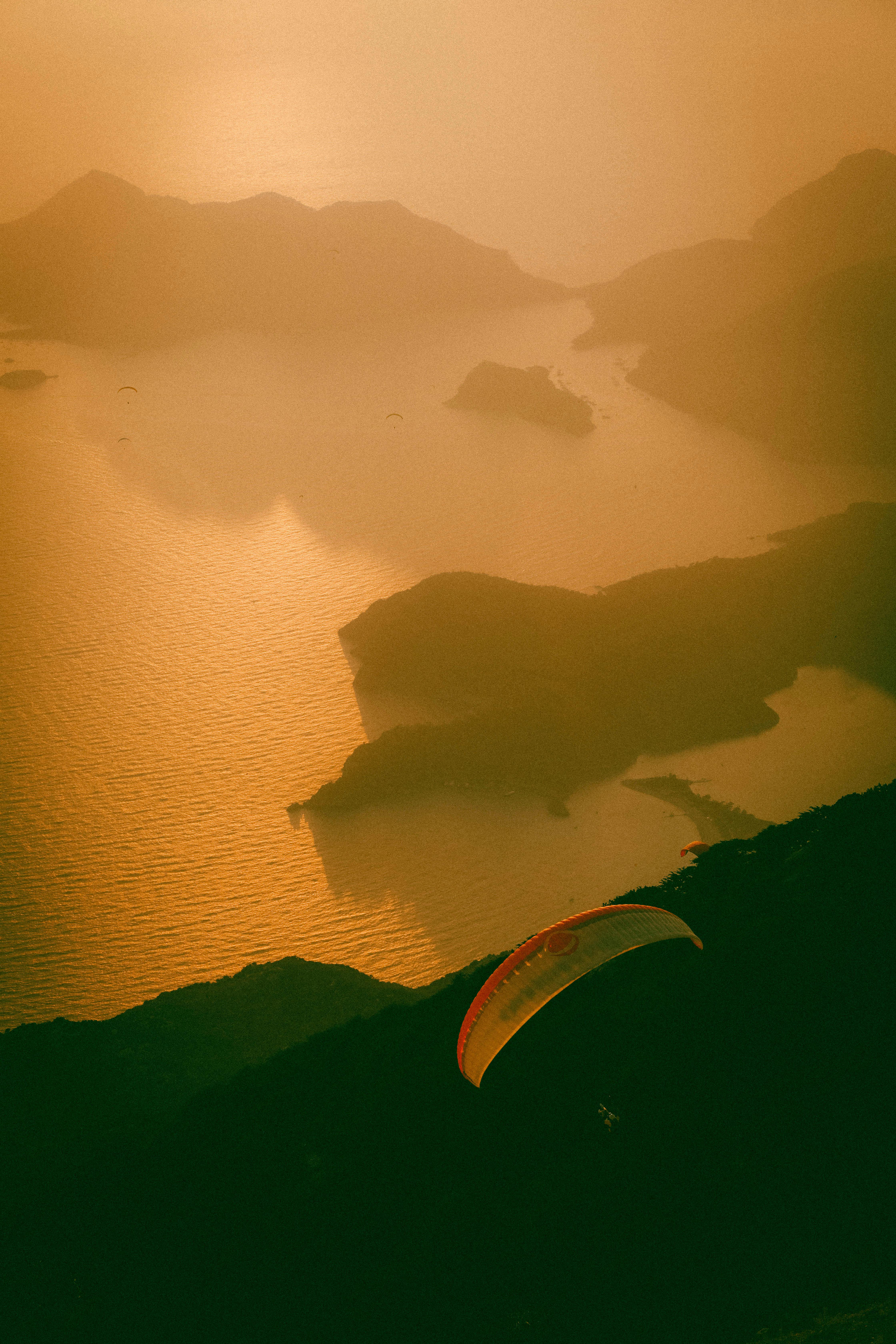 Breathtaking view of paragliding over Ölüdeniz, Turkey during a golden sunset.