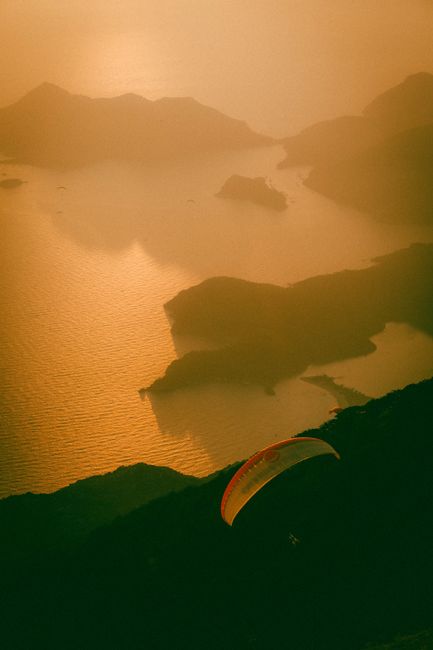 Breathtaking view of paragliding over Ölüdeniz, Turkey during a golden sunset.
