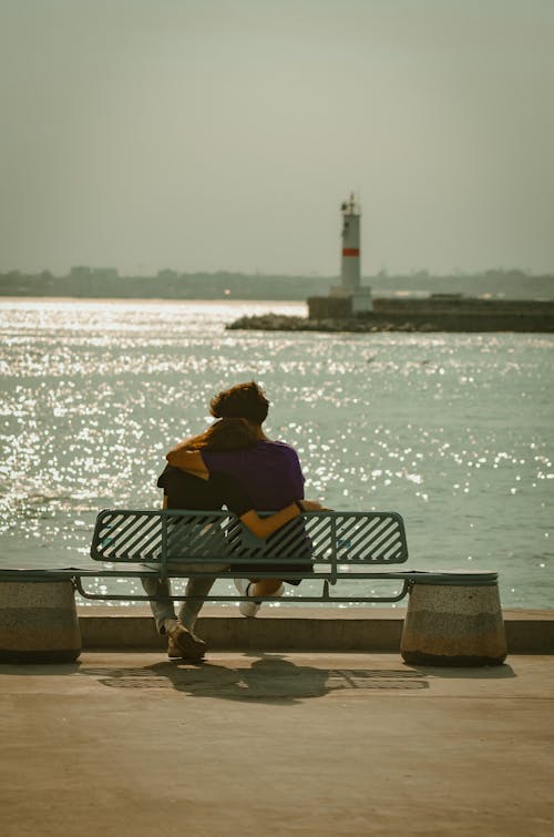 Couple Sitting on the Bench near Body of Water