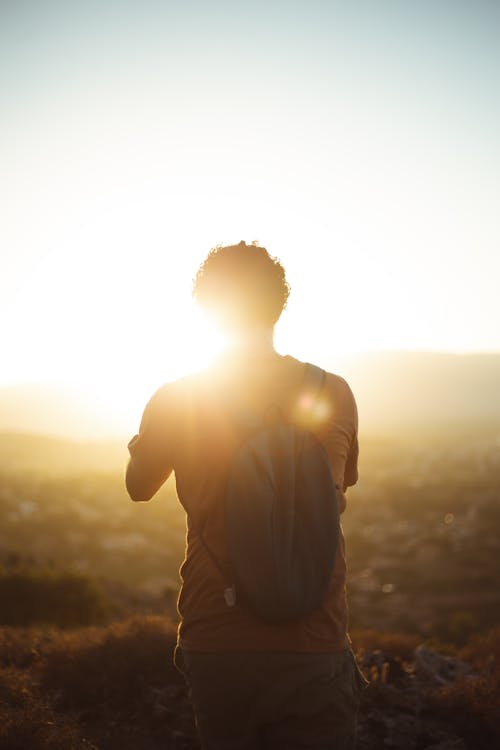 A Man Carrying Backpack During Sunset