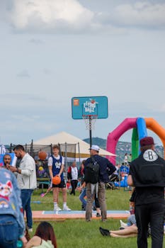 People enjoying a basketball game outdoors at a fun festival with a lively atmosphere.