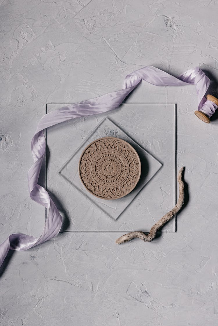 Ribbon And An Ornamented Wooden Circle On Glass