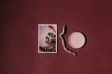Printed art card on a deep red surface, by Lisett Kruusimäe on Pexels