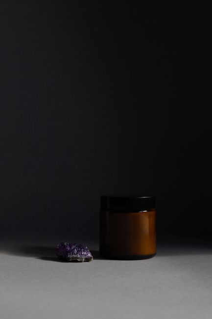 Elegantly composed dark jar and amethyst stone in minimalist still life photography. - Where to Buy Authentic Shilajit in Pakistan