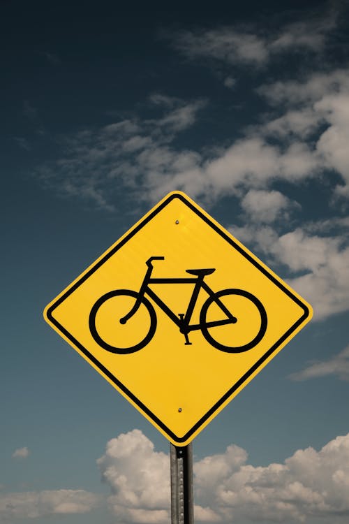 A Bicycle Lane Signage Under the Blue Sky and White Clouds