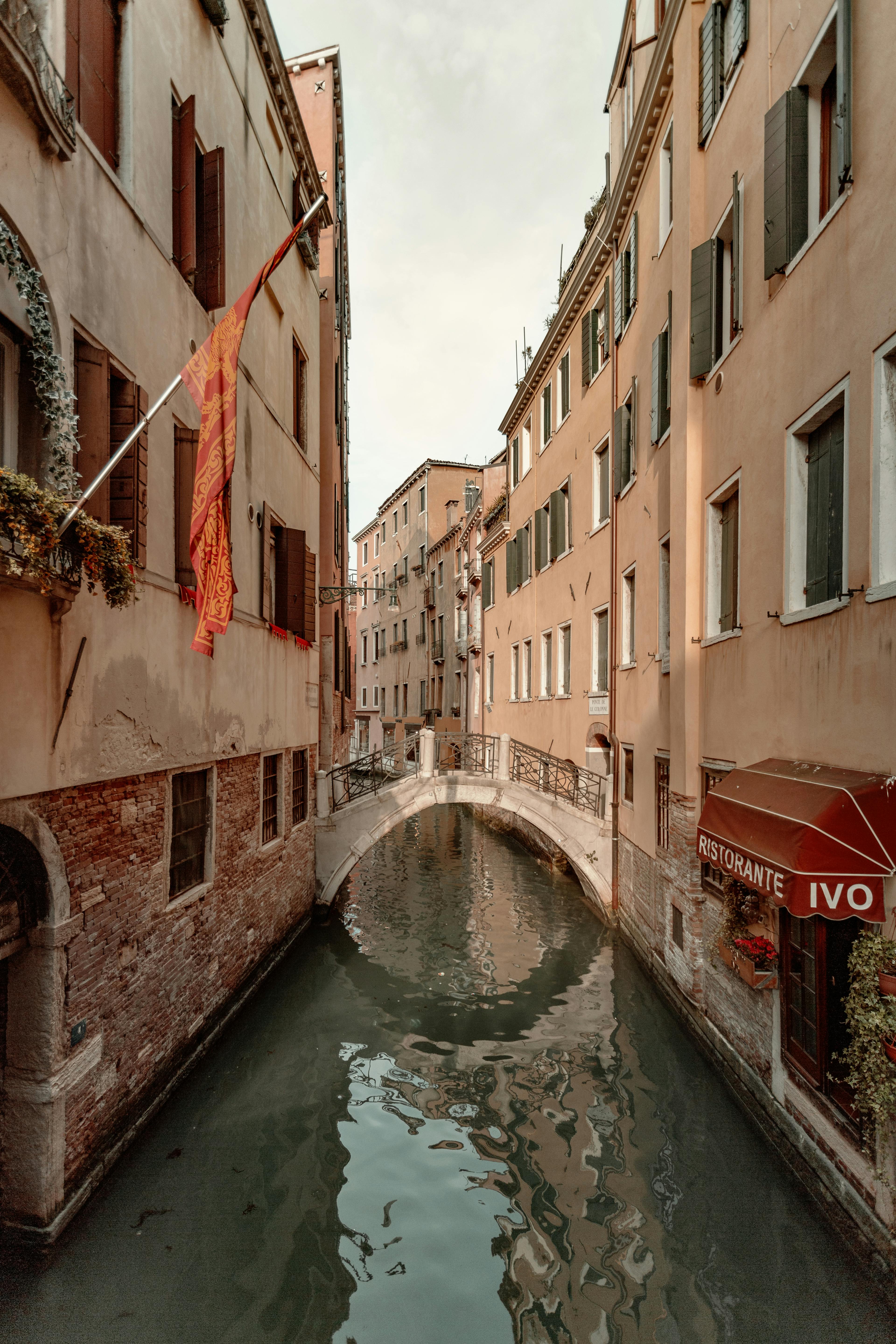 Serene view of a narrow canal with traditional buildings and bridge in Venice, Italy