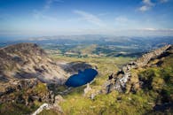 蔚蓝天空下，郁郁葱葱的山间湖泊呈现出一幅壮丽的鸟瞰图