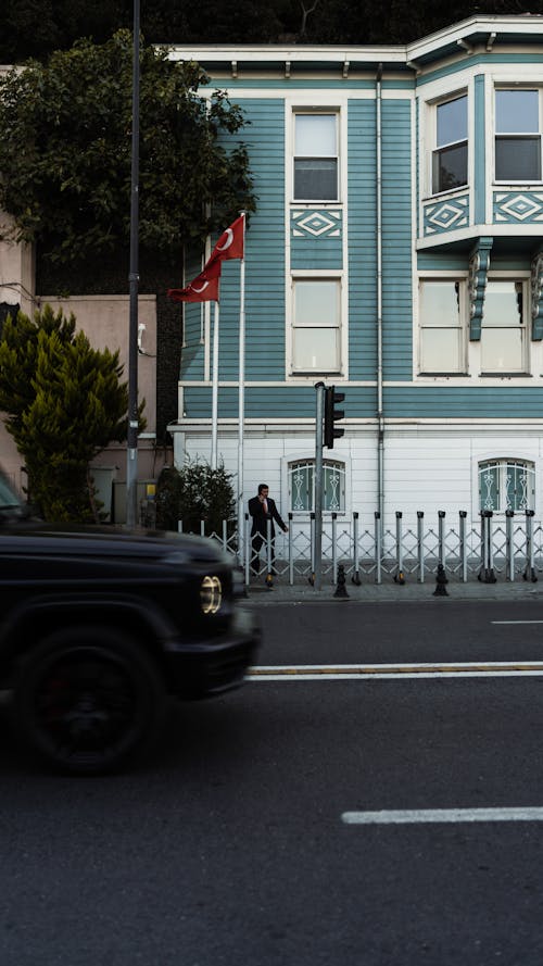 Car on a City Street in front of Traditional House Facade 