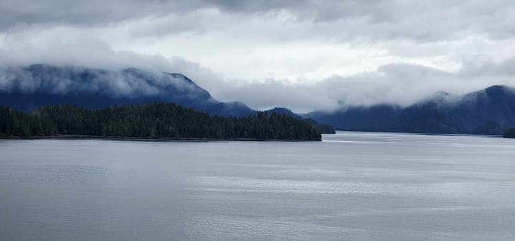 A serene view of misty mountains and calm waters in Sitka, Alaska.