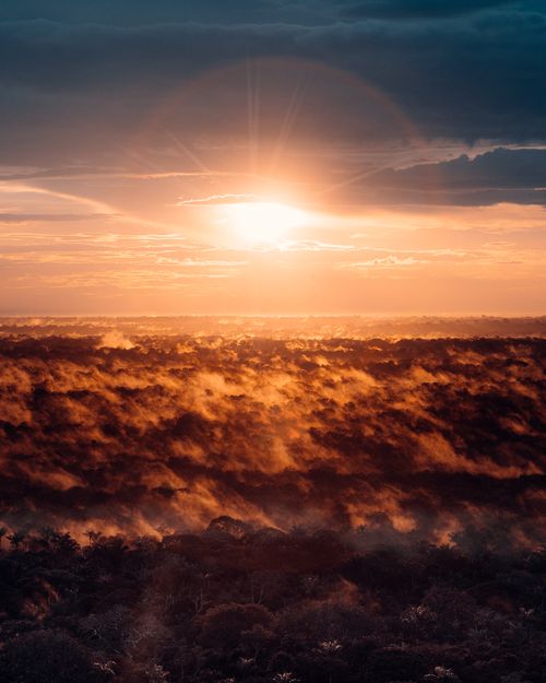 Free A breathtaking sunrise over foggy forests in Guaviare, Colombia, captured from above. Stock Photo