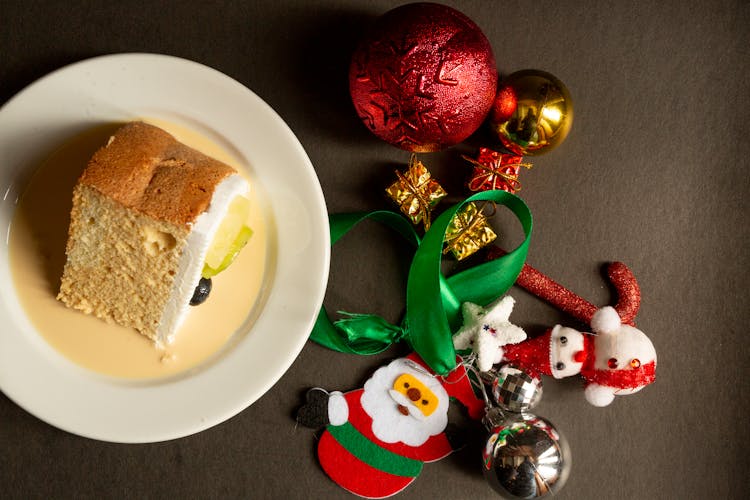 Slice Of Cake On A Plate And Christmas Decorations