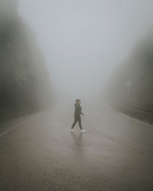 Free Photo of a Person walking on Foggy Road Stock Photo