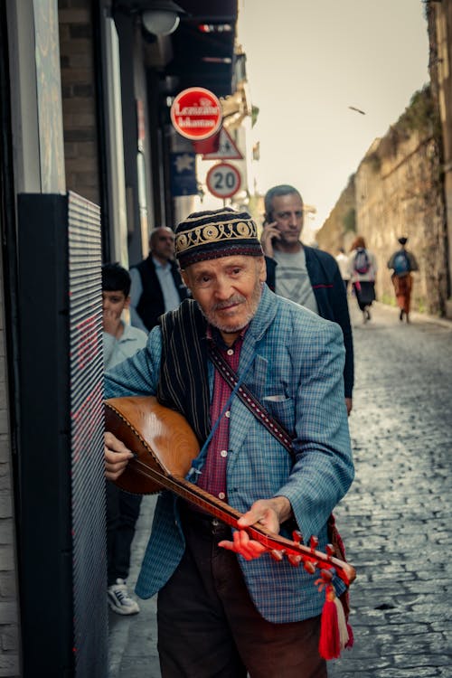 Elderly Man on the Street Playing a String Instrument 