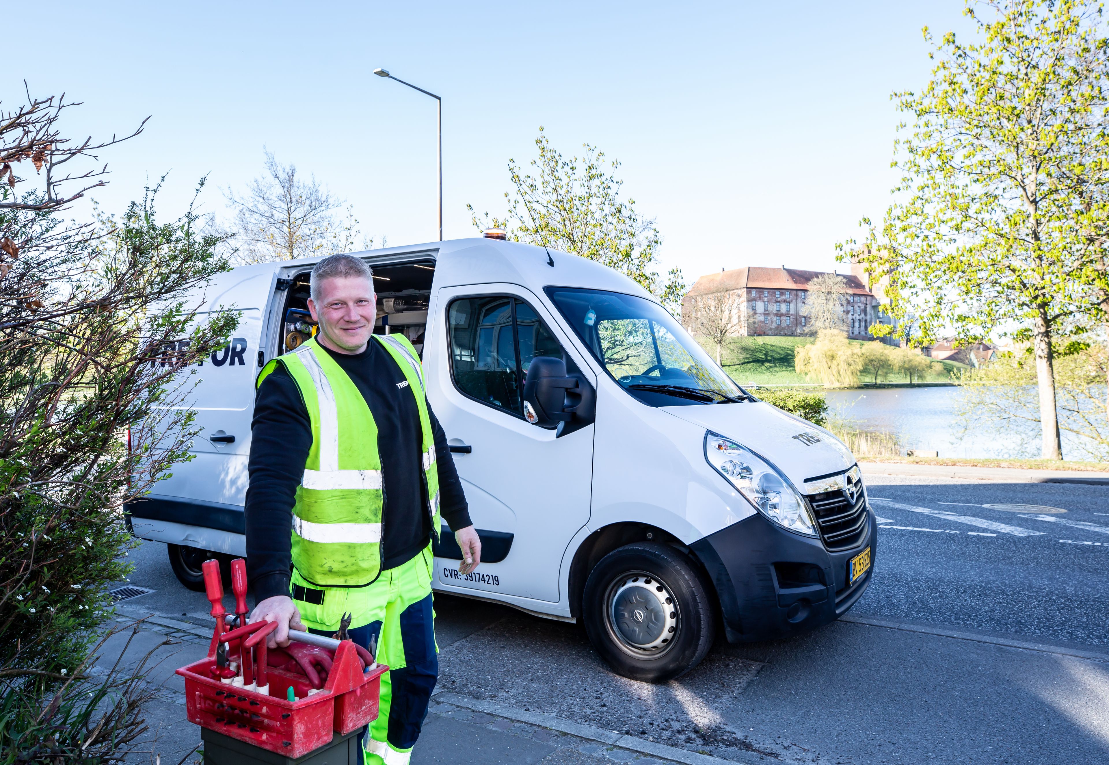 A tradesman with his tool case beside his work van