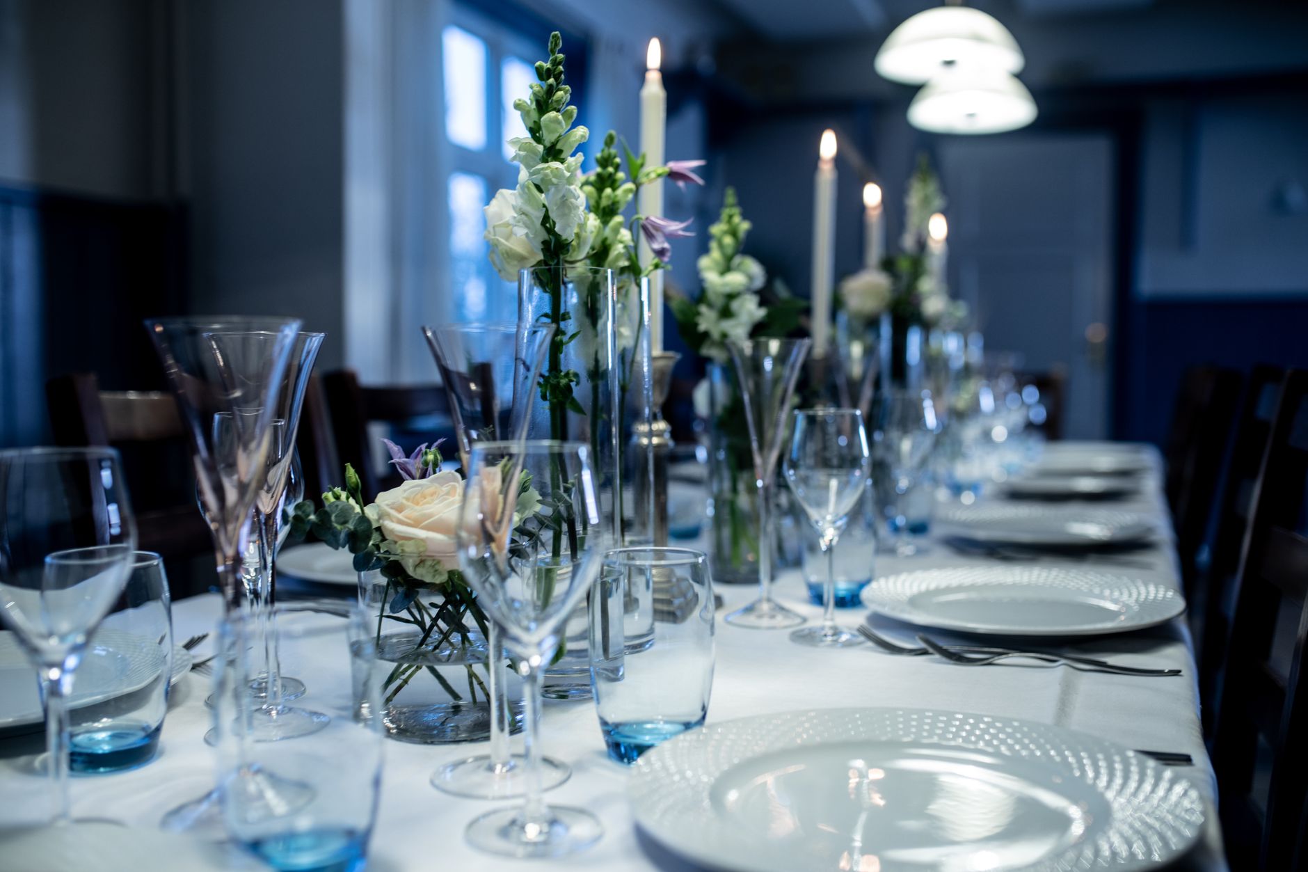 Beautifully decorated table setting with flowers, glasses, and candles.
