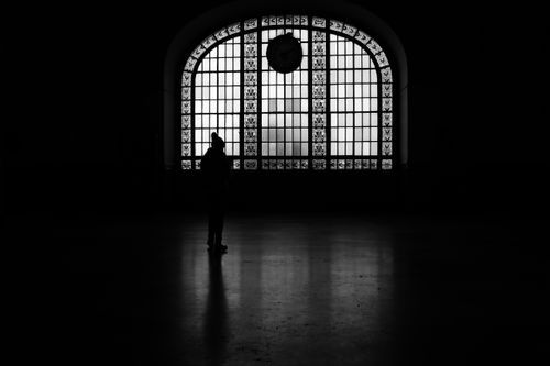 Free Silhouette of a woman standing alone in front of a large arched window at a historic site in Istanbul. Stock Photo
