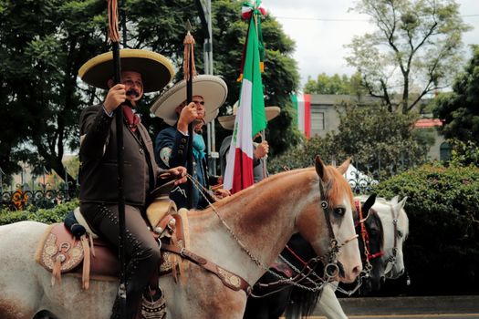 Men in Charro Costumes and Sombreros Riding Horses at a Parade