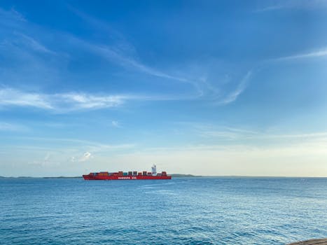 A red container ship sails under a blue sky off the coast of Cartagena, Colombia.