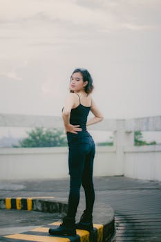 Fashionable woman poses confidently outdoors in a casual outfit in Cimahi, Indonesia.