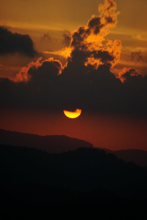 Free Stunning sunset with silhouetted mountains and clouds in Idukki, India. Stock Photo