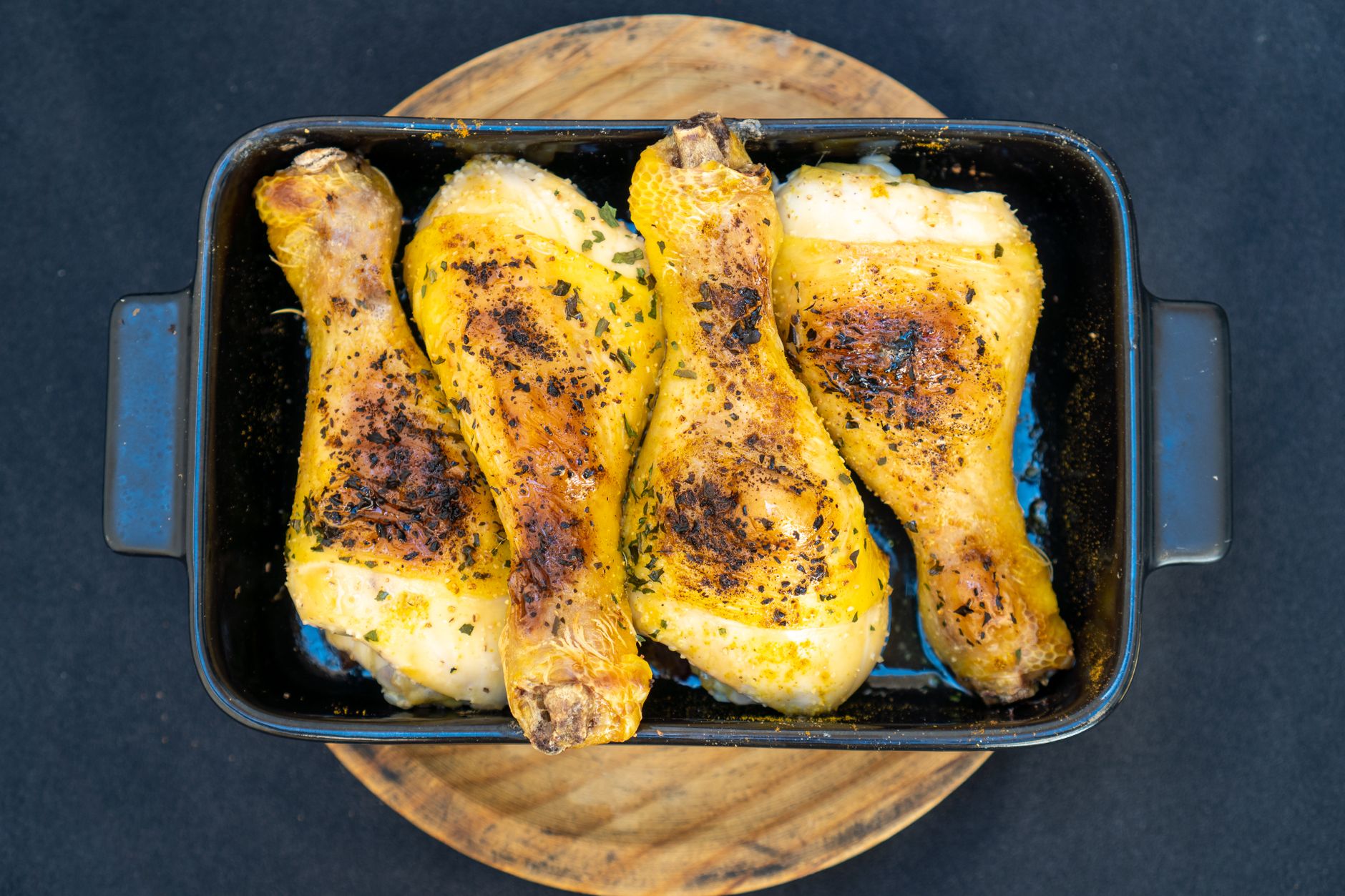 Seasoned chicken roasting in a Dutch oven with fresh herbs