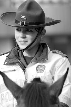 Black and white portrait of a policewoman in uniform, showcasing authority and duty.