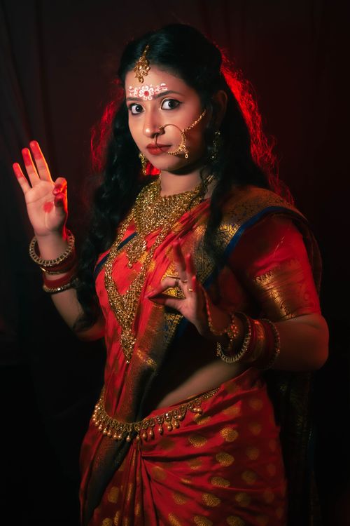 Free Elegant portrait of an Indian woman in red traditional attire, showcasing cultural jewelry. Stock Photo