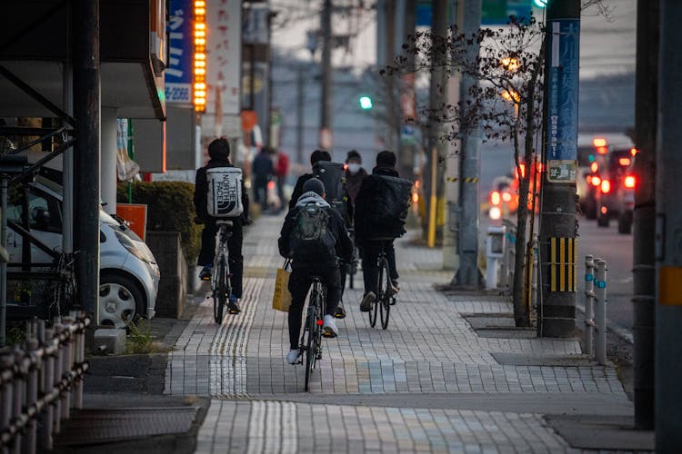 People Riding Bicycles On The Sidewalk