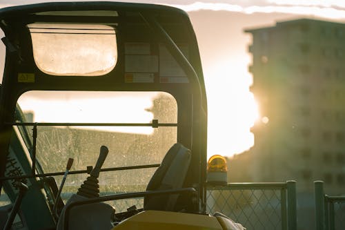 Silhouetted Construction Vehicle and a Block of Flats in the Background 