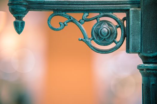 Close-up of ornate green iron decoration with vintage design, perfect for architectural details.
