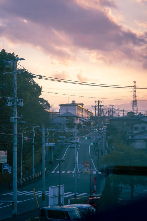 Free Peaceful city street scene under a dramatic sunset sky, capturing urban life. Stock Photo