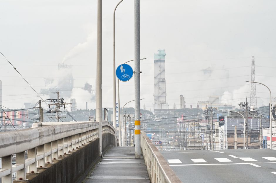煙突と空の通りを持つ都市の産業シーンで、都市化を示しています。