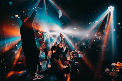 Free Exciting nightclub scene with people dancing and vibrant colored lights creating a lively atmosphere. Stock Photo