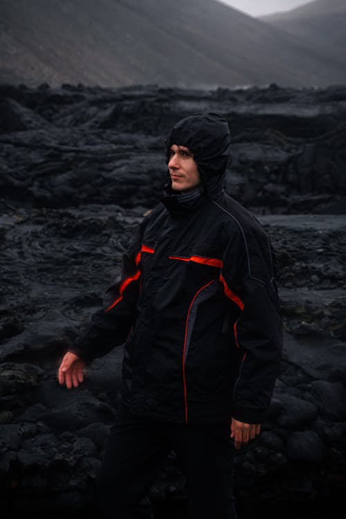 A Man in Black Hoodie Jacket Standing Near the Rock Formation