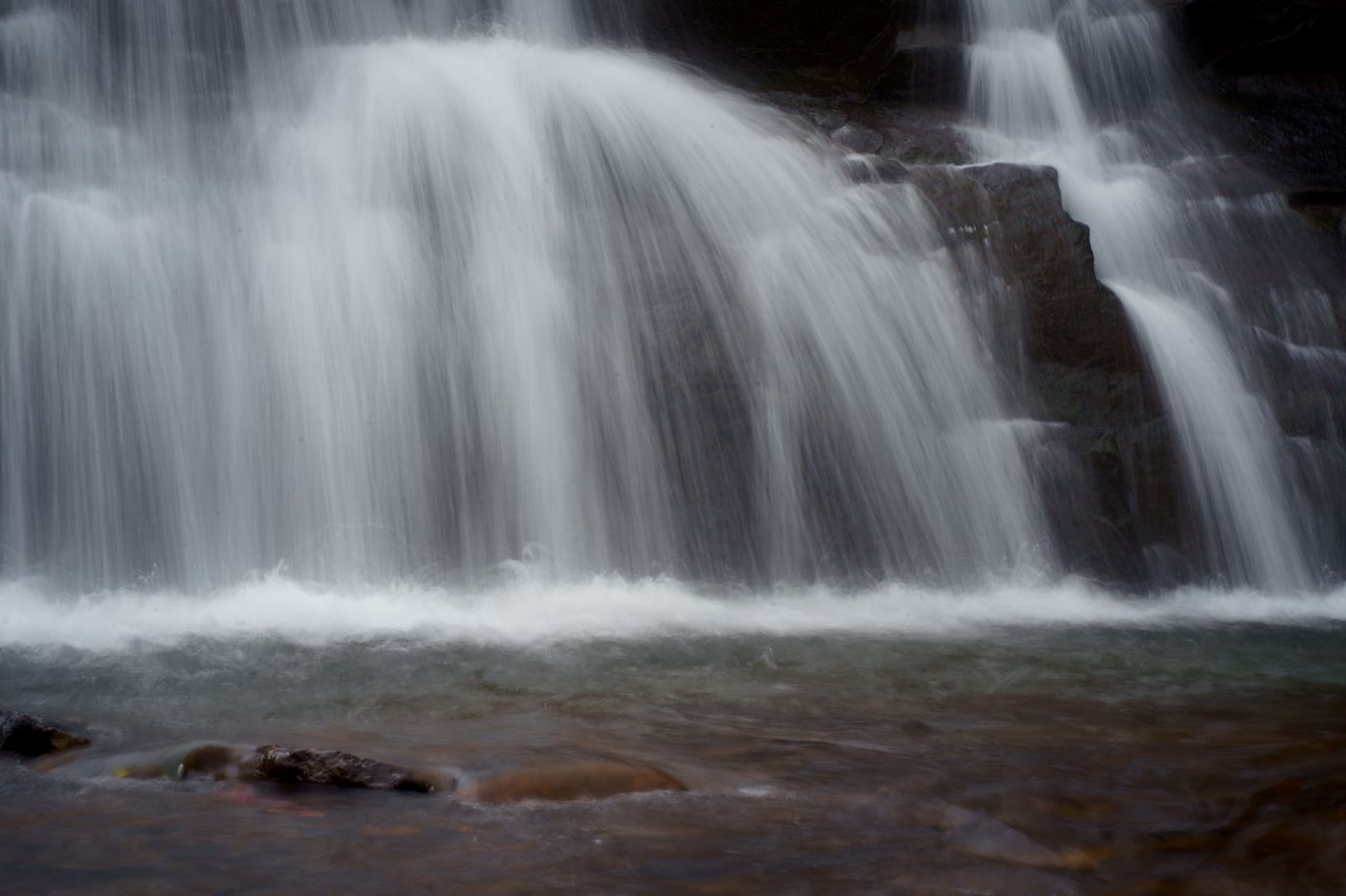 Gentle cascade flowing over mossy rock shelves