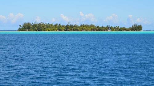 Free A serene tropical island with clear turquoise waters and lush greenery. Stock Photo