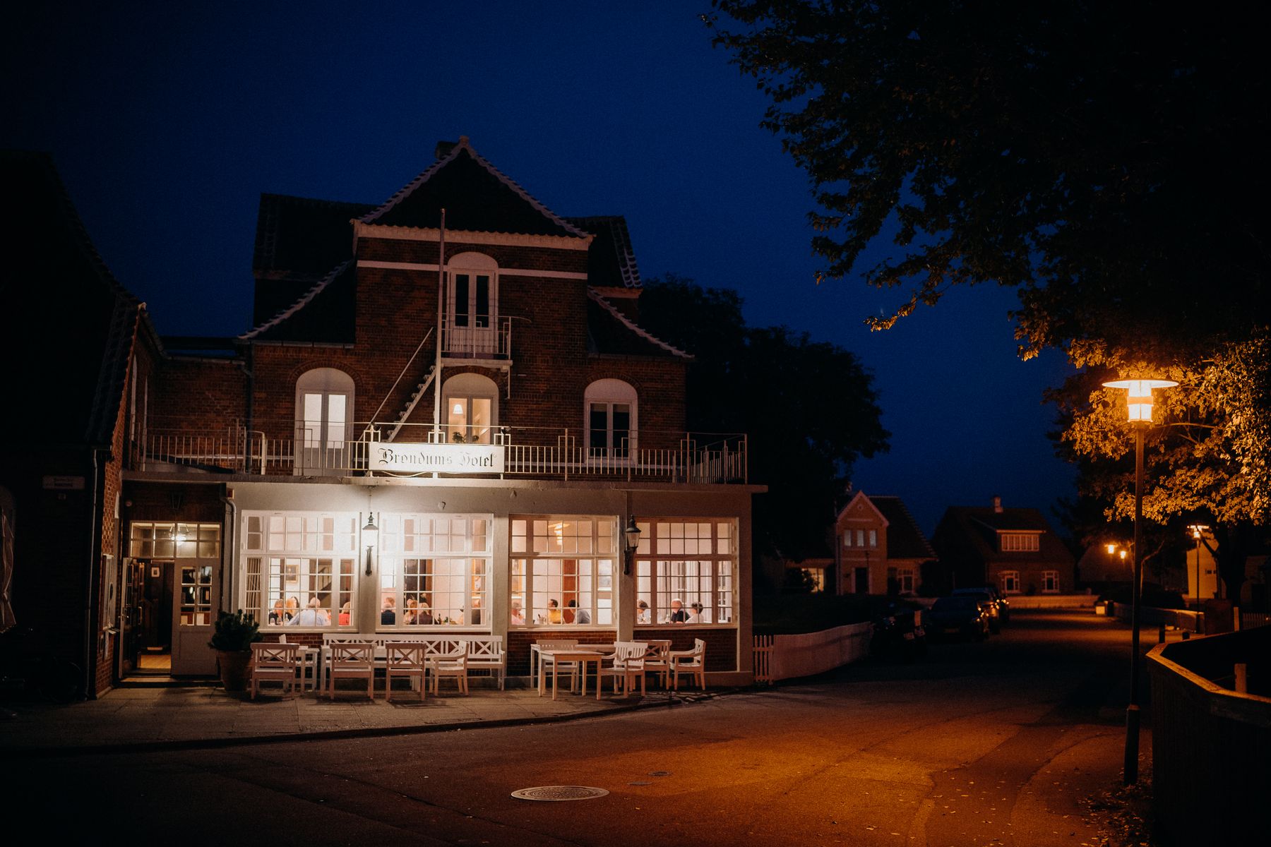 The hotel's brick exterior, warmly lit at dusk with an inviting entrance