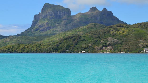 Stunning view of a lush green island mountain rising above a turquoise sea.
