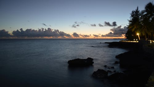 Silhouette of Rocks on Sea Under Evening Sky