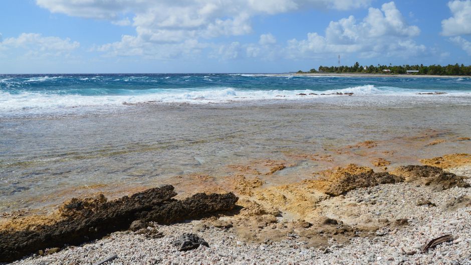 Beautiful coastal view with rocky shoreline and clear blue ocean waves.