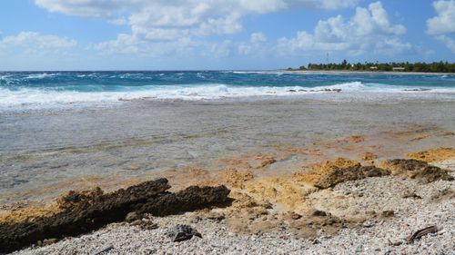 Free Beautiful coastal view with rocky shoreline and clear blue ocean waves. Stock Photo