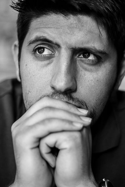 Fotomural Retrato en blanco y negro de un hombre profundo en pensamiento, con las manos descansando en su cara.