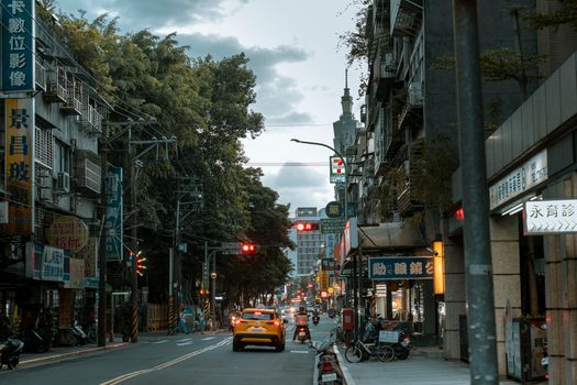 Street view in Taipei showcasing local architecture and vibrant city life with vehicles and pedestrians.